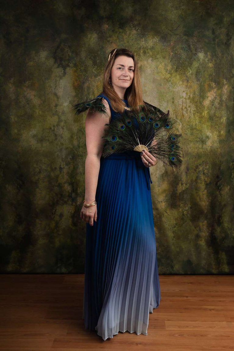 Photo of Sarah dressed as Hera, complete with peacock feathers and a laurel crown